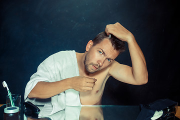 Image showing Man With Comb Concerned About Hair Loss