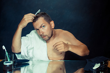 Image showing Man With Comb Concerned About Hair Loss