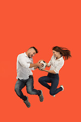 Image showing The young man and woman as soccer football players kicking the ball at studio