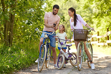 Image showing family with smartphone and bicycles in summer park