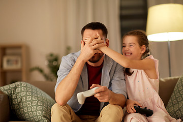 Image showing father and daughter playing video game at home