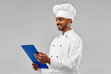 Image showing happy male indian chef in toque with clipboard