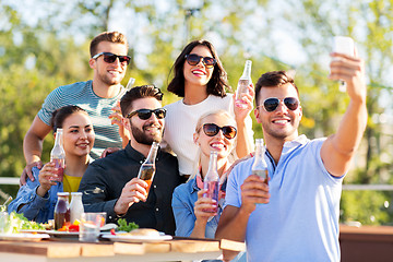 Image showing happy friends taking selfie at rooftop party