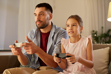 Image showing father and daughter playing video game at home