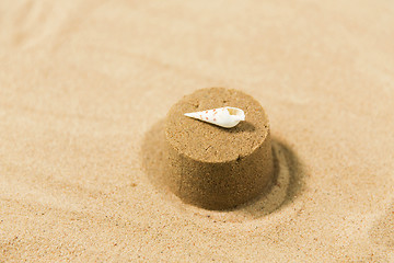 Image showing sand shape made by mold with shell on summer beach