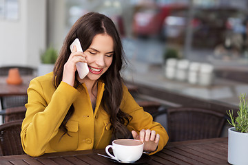 Image showing teenage girl calling on smartphone at city cafe