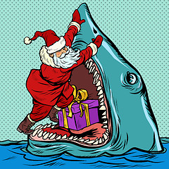 Image showing Santa Claus pushes Christmas gift into shark mouth