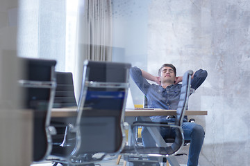 Image showing young businessman relaxing at the desk