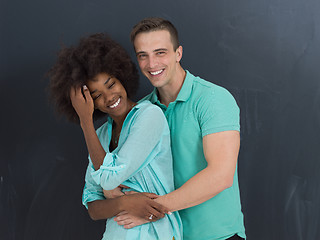 Image showing multiethnic couple in front of gray chalkboard