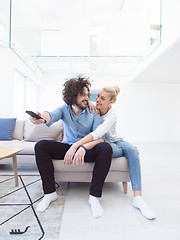 Image showing Young couple on the sofa watching television