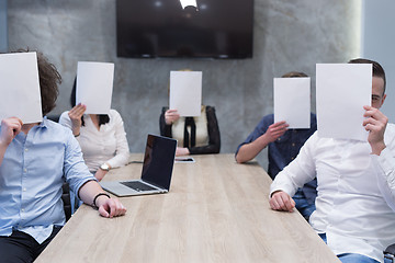 Image showing startup business team holding a white paper over face