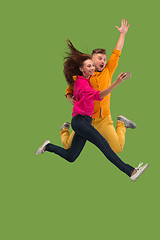 Image showing Full length of young couple with mobile phone while jumping