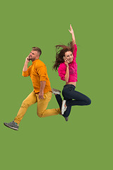 Image showing Full length of young couple with mobile phone while jumping