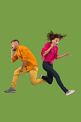 Image showing Full length of young couple with mobile phone while jumping