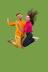 Image showing Full length of young couple with mobile phone while jumping
