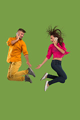 Image showing Full length of young couple with mobile phone while jumping