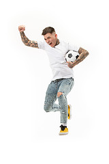 Image showing The young man as soccer football player kicking the ball at studio