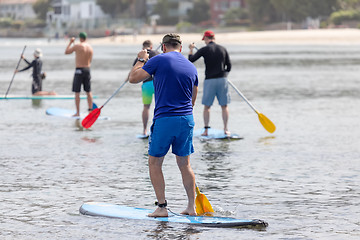 Image showing men paddling in the ocean