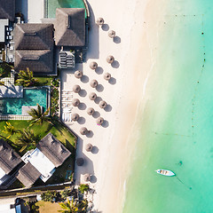 Image showing Aerial view of amazing tropical white sandy beach with palm leaves umbrellas and turquoise sea, Mauritius.