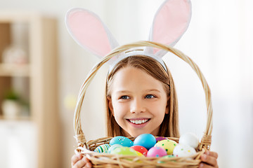 Image showing happy girl with colored easter eggs at home