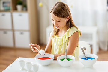 Image showing girl coloring easter eggs by liquid dye at home