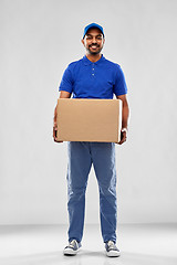 Image showing happy indian delivery man with parcel box in blue