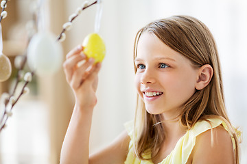 Image showing girl decorating willow by easter eggs at home