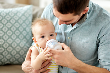 Image showing father and baby drinking from bottle at home