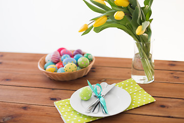 Image showing easter eggs in basket, plates, cutlery and flowers