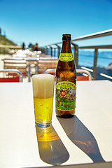 Image showing Bottle and glass of popular non alcoholic apple beer in restaura