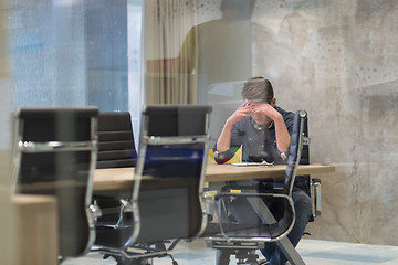 Image showing young businessman relaxing at the desk