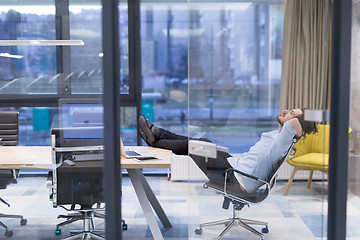 Image showing young businessman relaxing at the desk