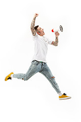 Image showing Jumping fan on white background. The young man as soccer football fan with megaphone