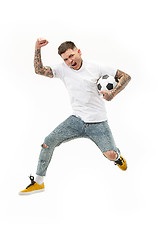 Image showing The young man as soccer football player kicking the ball at studio