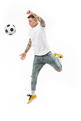 Image showing The young man as soccer football player kicking the ball at studio