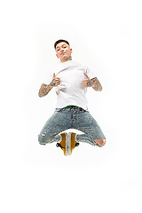 Image showing Image of young man over white background using laptop computer while jumping.