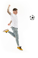 Image showing The young man as soccer football player kicking the ball at studio