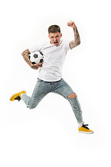 Image showing The young man as soccer football player kicking the ball at studio