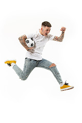 Image showing The young man as soccer football player kicking the ball at studio