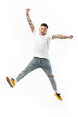 Image showing Freedom in moving. handsome young man jumping against white background