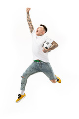 Image showing The young man as soccer football player kicking the ball at studio