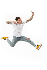 Image showing Full length of handsome young man taking selfie while jumping