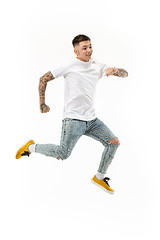 Image showing Freedom in moving. handsome young man jumping against white background