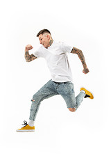 Image showing Freedom in moving. handsome young man jumping against white background