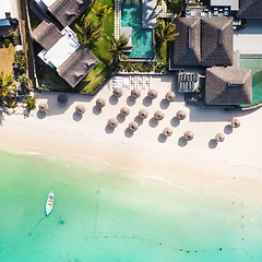 Image showing Aerial view of amazing tropical white sandy beach with palm leaves umbrellas and turquoise sea, Mauritius.