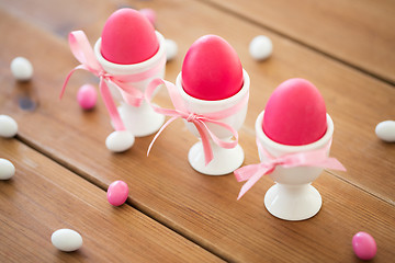 Image showing easter eggs in holders and candy drops on table