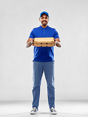 Image showing happy indian delivery man with pizza boxes in blue