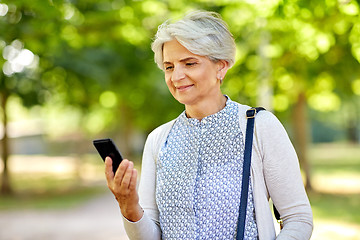 Image showing happy senior woman with smartphone at summer park