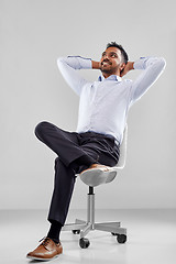 Image showing smiling indian businessman sitting on office chair