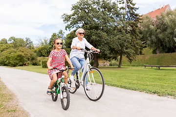 Image showing grandmother and granddaughter cycling at park